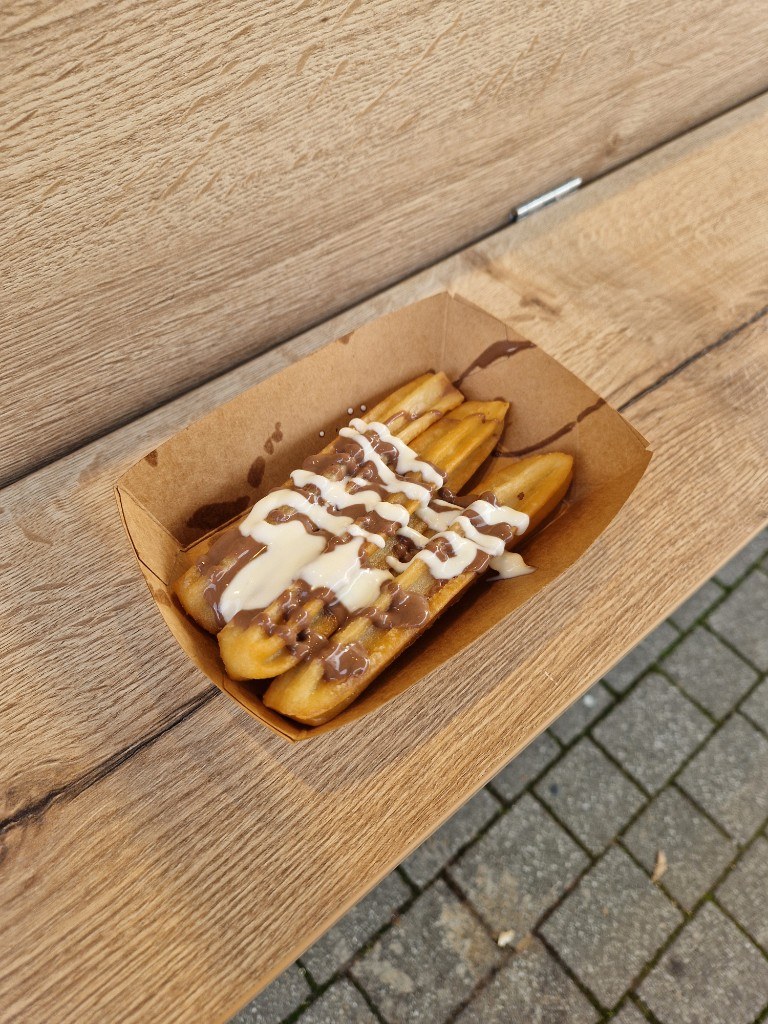 Frische Churros mit Schoko- und weißer Glasur