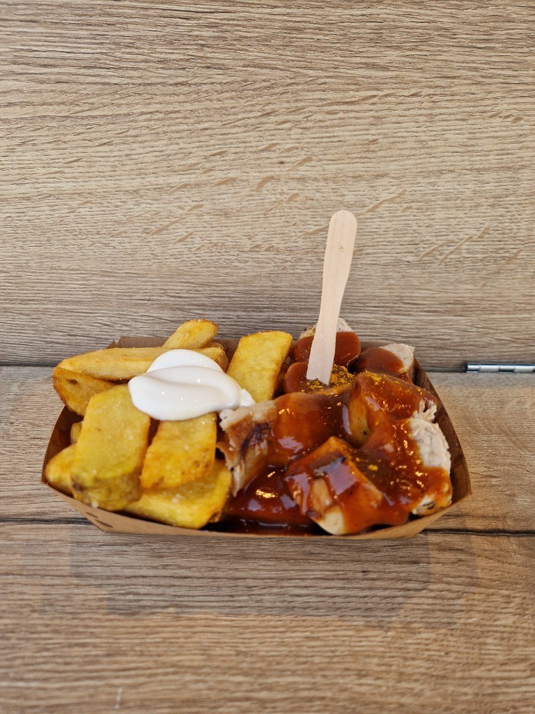 Currywurst mit Pommes und Mayo im Schiffchen